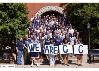 group of people holding 'we are c' signs outdoors