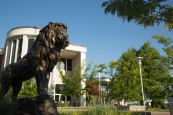 lion statue in front of a campus building