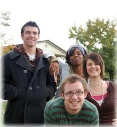 group of four smiling students outdoors