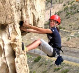 person rock climbing with a helmet smiling