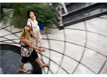 two women walking down busy hallway