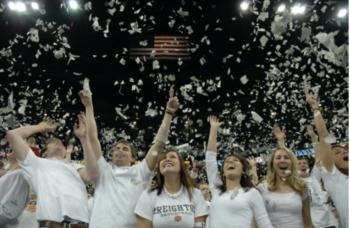 crowd celebrating with 'creighton' shirts and confetti