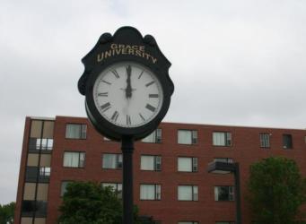 campus clock with 'grace university' on it, cloudy sky