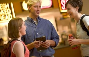 three students chatting near 'naked bread' cafe