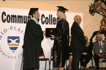 graduation ceremony with 'Community College' banner in background