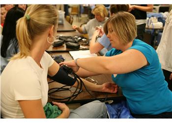 student taking blood pressure of another student