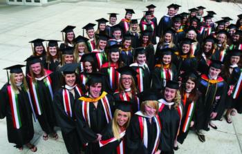 group of graduates in caps and gowns smiling