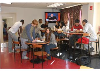 students socializing in a lounge with tv in background