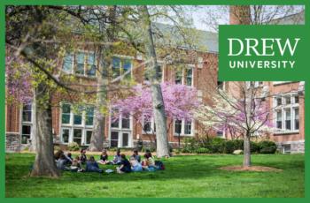 students seated on grass for a class with 'drew university' logo