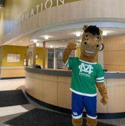 mascot posing in front of 'information' desk