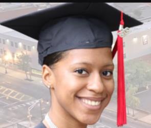 graduating student smiling with campus in background