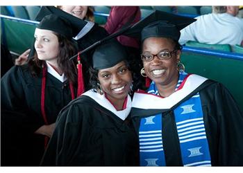 two graduates smiling in cap and gown