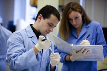 two students in lab coats conducting an experiment