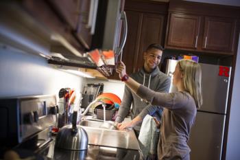 two students cooking together in a kitchen