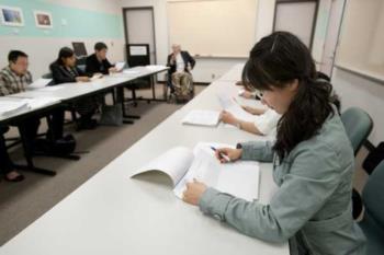 students focused on work in a classroom setting with instructor