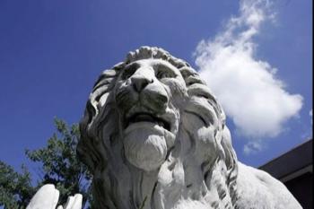 white lion statue against clear blue sky