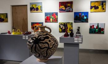 art exhibition with pottery and colorful paintings