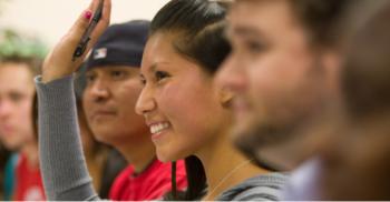 student raising hand in a classroom