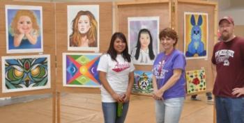 four people smiling by art displays