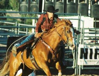 cowboy riding a horse in a rodeo arena