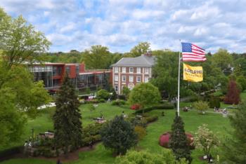 campus view with american flag and adelphi banner