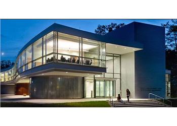 modern building at dusk with illuminated interior and people