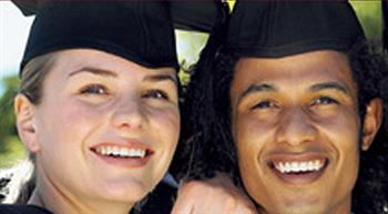 two smiling graduates in caps