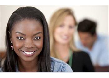 smiling woman in focus with two people blurred in background