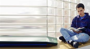 student reading a book while sitting on the floor