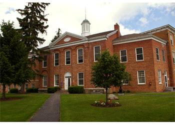 brick building with white columns and a cupola