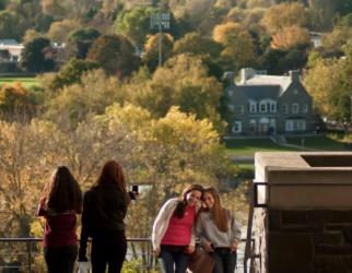 group of people posing for photo with campus in background