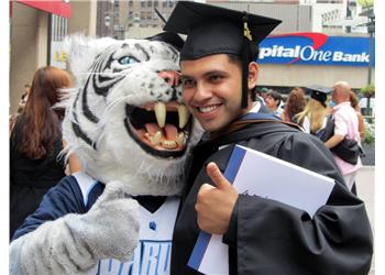 graduate posing with a mascot