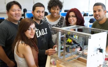 students around a tech project