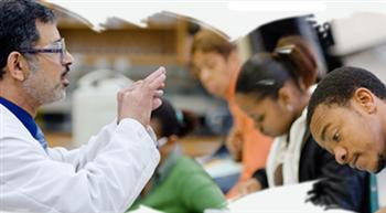 students in lab coats during a class discussion