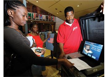 two people at an information desk with a laptop