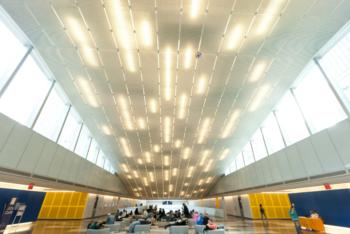 modern indoor space with people sitting under lit ceiling