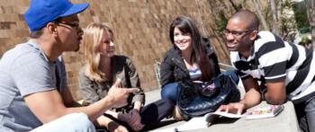 four students sitting and chatting outdoors