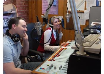 two people smiling in a radio studio