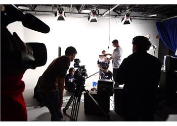 film crew working in a studio with camera and lighting