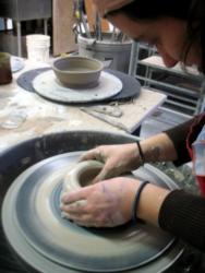 person shaping clay on a potter's wheel