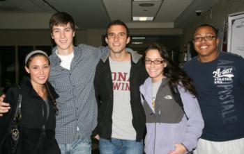 group of five smiling students indoors