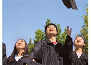 graduates looking up at flying graduation caps