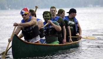 team paddling in a canoe race on a lake