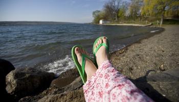 person relaxing by the lake with feet up