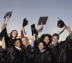 graduates tossing up hats with a blue sky background