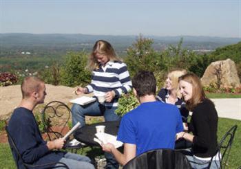 group of students studying outdoors at a table