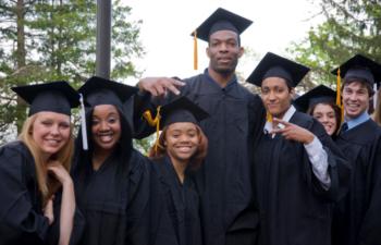 graduates posing, one making a victory sign