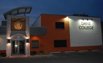 evening view of 'Davis College' building with illuminated sign