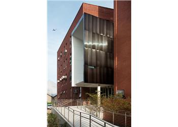 modern brick building with metal paneling and walkway