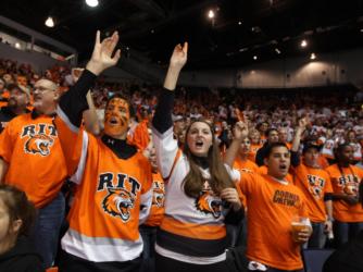 fans in orange cheering at a 'RIT Tigers' sporting event